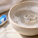 A diamond ring soaking in warm soapy water for at-home cleaning