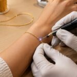 Jeweller welding a fine gold permanent bracelet closed on a customer's wrist