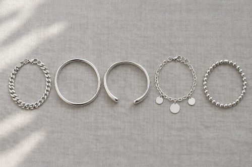 Five types of sterling silver bracelets side by side: curb chain, bangle, cuff, charm and beaded bracelet Five types of sterling silver bracelets side by side: curb chain, bangle, cuff, charm and beaded bracelet